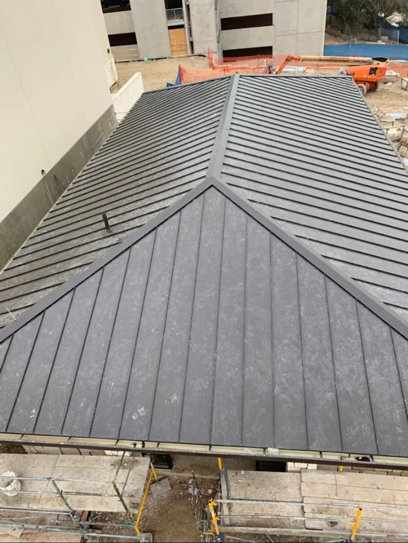 Commercial metal roof construction with crane equipment in Tecumseh